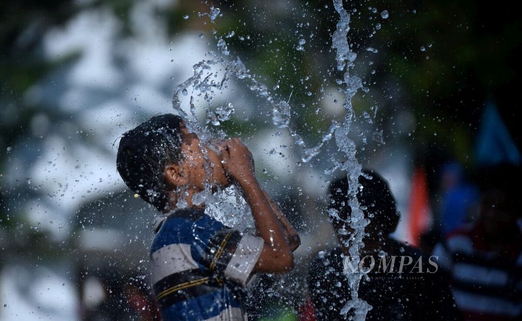 Anak-anak bermain di air mancur di sekitar Tugu Pahlawan, Surabaya, Jatim, Senin (1/5). Aktivitas itu untuk mengurangi dampak cuaca panas.