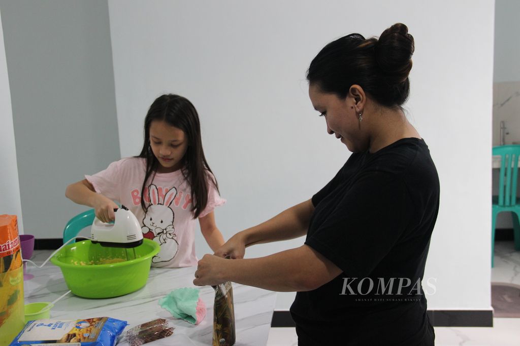 Salah seorang umat Gereja Persekutuan Pemberitaan Injil Kristus (GPPIK) Bukit Zaitun Pontianak, Kalimantan Barat, sedang membuat kue bersama anaknya, Selasa (20/12/2022).