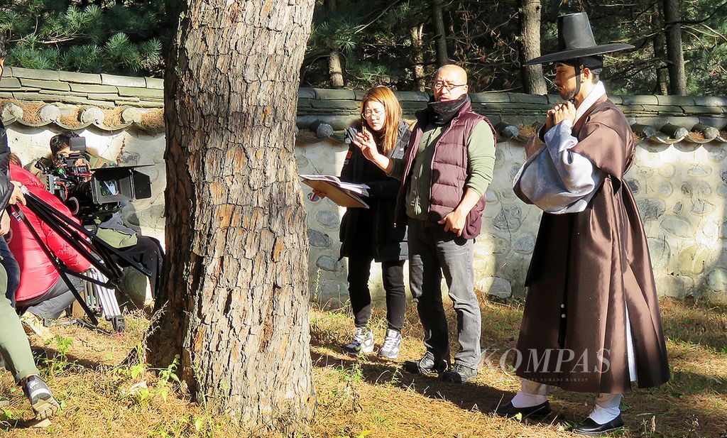 Aktor Song Seung-heun, yang berperan sebagai Lee Kyeom (kanan, memakai baju tradisional Korea), berdiskusi dengan sutradara Yun Sang-ho (kedua dari kanan) di sela pengambilan gambar untuk serial drama <i>Saimdang, The Her Story</i> di kawasan kompleks rumah pribadi perempuan seniman abad ke-15 Korea, Shin Saimdang, di Kota Gangneung, Korea Selatan, 30 November 2015. 