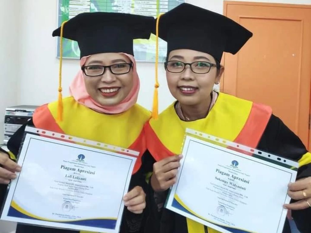 Dari kiri: Lofi Loliyanti (38) dan Sukempy Widyastuti (38) saat wisuda di Singapura, Minggu (13/3/2022). Mereka adalah dua pekerja migran asal Indonesia yang merupakan lulusan terbaik Universitas Terbuka kelompok belajar Singapura.