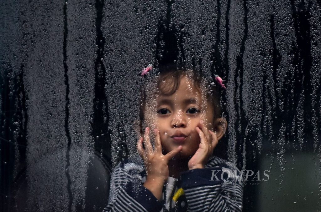 Seorang anak terlihat di balik jendela bus saat acara pemberangkatan Mudik Bareng Gratis 2022 di Depan Kantor Dishub Jawa Timur, Kota Surabaya, Jawa Timur, Kamis (28/4/2022). 