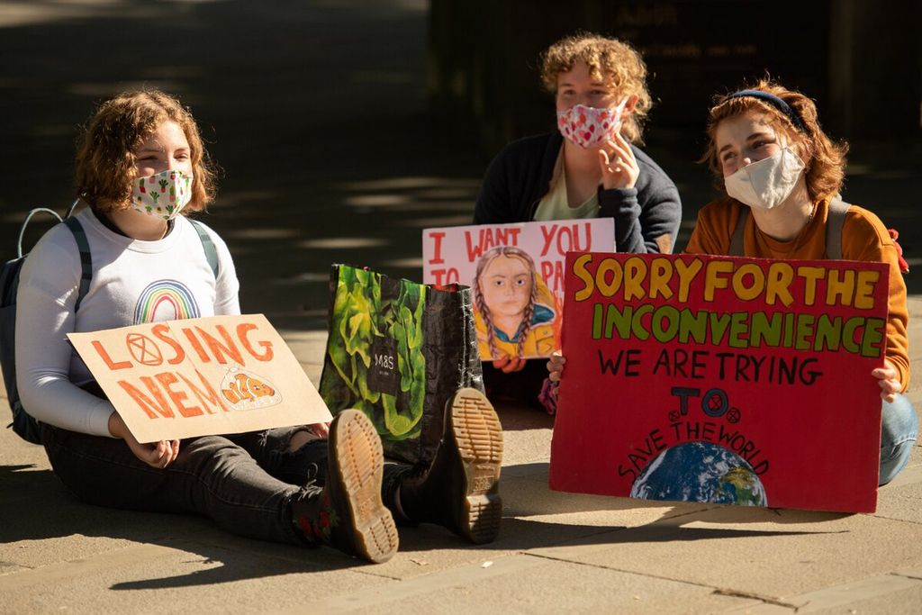 Perempuan aktivis dari kelompok Extinction Rebellion menggelar aksi di Manchester, Inggris, Selasa (1/9/2020). Aksi yang menyuarakan dampak perubahan iklim berlangsung di sejumlah tempat di Inggris.