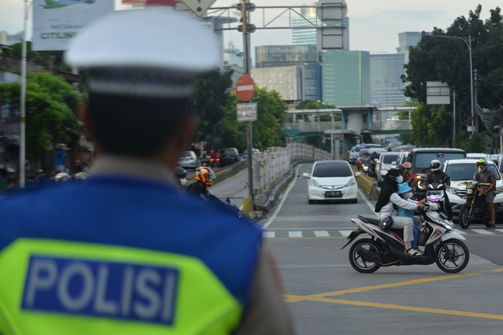 Pengendara sepeda motor melintas di Jalan Mampang Prapatan, Jakarta Selatan, Minggu (20/11/2022), tanpa menggunakan helm. 