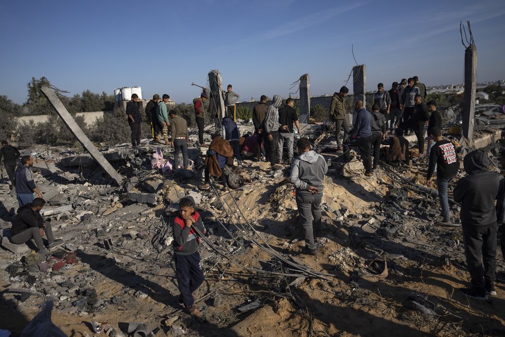 Warga Palestina mencari jenazah dan korban selamat di reruntuhan rumah yang hancur akibat serangan udara Israel, di Rafah, Jalur Gaza selatan, Minggu (7/1/2024).