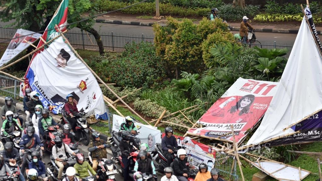 Sejumlah baliho dan poster iklan kampanye para caleg dalam Pemilu 2019 roboh diempas hujan angin di Jalan Gatot Subroto, Jakarta, Kamis (4/4/2019).