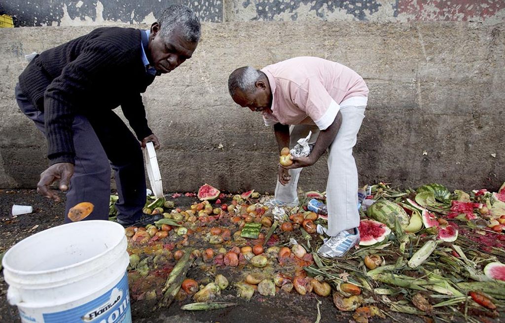 Dalam foto bertanggal 31 Mei 2016 ini, Pedro Hernandez (kiri) dan temannya, Luis Daza, mengumpulkan tomat dari tempat pembuangan sampah di sebuah pasar, di Caracas, Venezuela. Warga Venezuela menghadapi kesulitan mendapatkan makanan karena langka dan harga tidak terjangkau. 