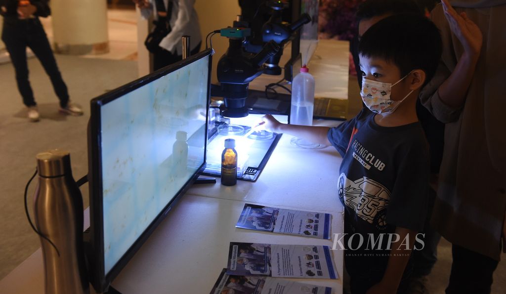 Visitors observe microplastics in the river water at the Ecoton booth during the ArtXhibition at Ciputra World, Surabaya, East Java, on Friday (5/5/2023). At the booth, visitors gain knowledge about the dangers of plastic in everyday life.