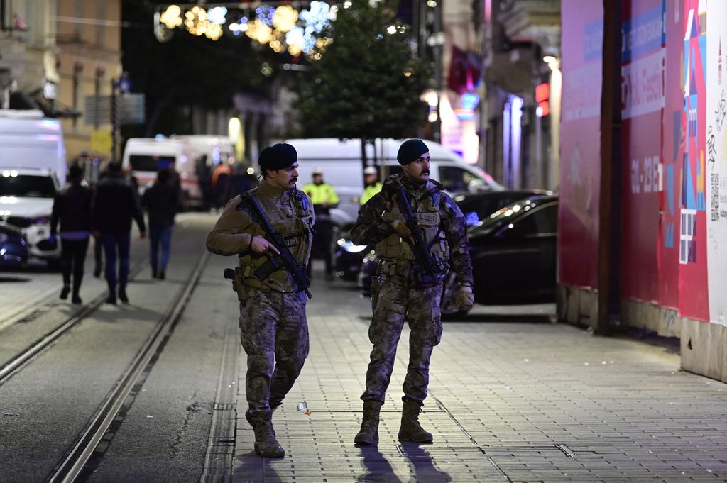 Dua polisi Turki menjaga wilayah sekitar lokasi ledakan di Istiklal Avenue, Istanbul, Minggu (13/11/2022) petang. 