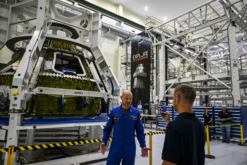 Astronot dari Badan Luar Angkasa Eropa Alexander Gerst (kiri) berdiri di sebelah kapsul Orion yang akan diluncurkan dalam misi Artemis, di Gedung O & C di Pusat Luar Angkasa Kennedy di Cape Canaveral, Florida, AS, Minggu (28/8/2022). 