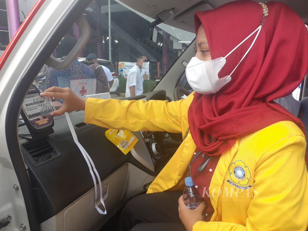 Seorang mahasiswi sedang menempelkan kartu uang elektronik pada angkutan pengumpan (feeder) di Palembang, Sumatera Selatan, Minggu (27/2/2022).