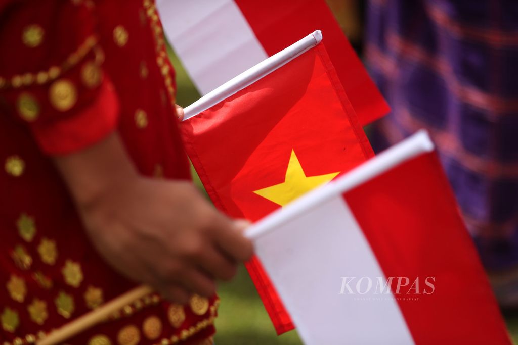 Pelajar membawa bendera Indonesia dan Vietnam saat menyambut Presiden Joko Widodo dan Presiden Vietnam Nguyen Xuan Phuc dalam upacara penyambutan di Istana Kepresidenan, Bogor, Jawa Barat, Kamis (22/12/2022). 