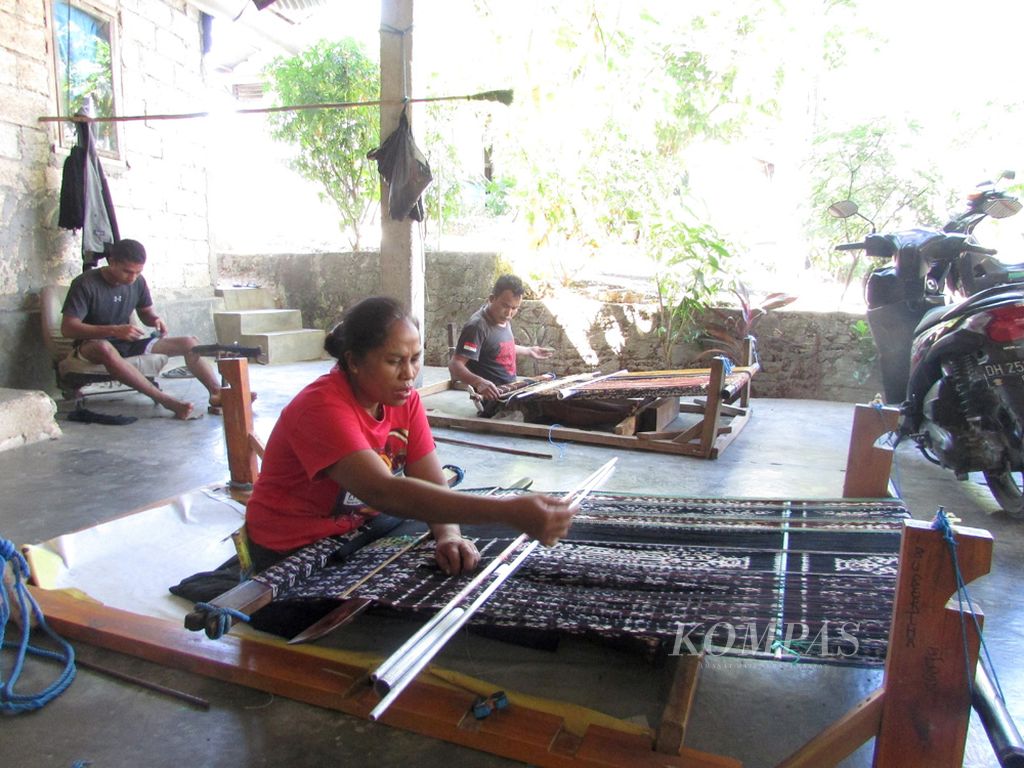 Bertha Taduhere (52) dan Andreas Rihi (45) sedang menenun di rumah Bertha, Jumat (12/6/2020). Mereka adalah anggota kelompok tenun "Mira Kaddi", Kota Kupang, karena Covid-19 memilih menenun di rumah.