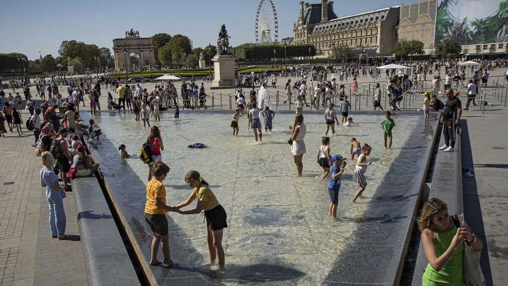 Warga memanfaatkan kolam di dekat Museum Louvre, Paris, Perancis, untuk menyegarkan diri, Kamis (11/8/2022). 