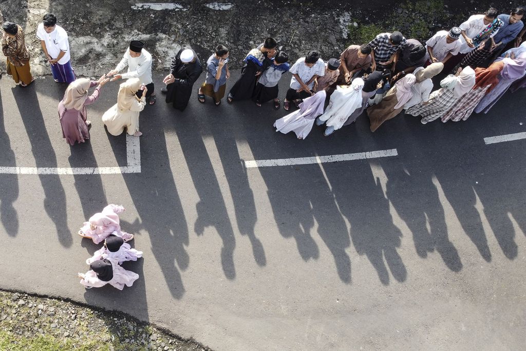 Foto udara sejumlah warga bersalaman seusai melaksanakan shalat Idul Fitri di Desa Darmaraja, Ciamis, Jawa Barat (10/4/2024). Tradisi bersalaman massal saat Lebaran antardusun tersebut dilaksanakan untuk saling memaafkan dan memperkokoh kerukunan antarumat beragama. 