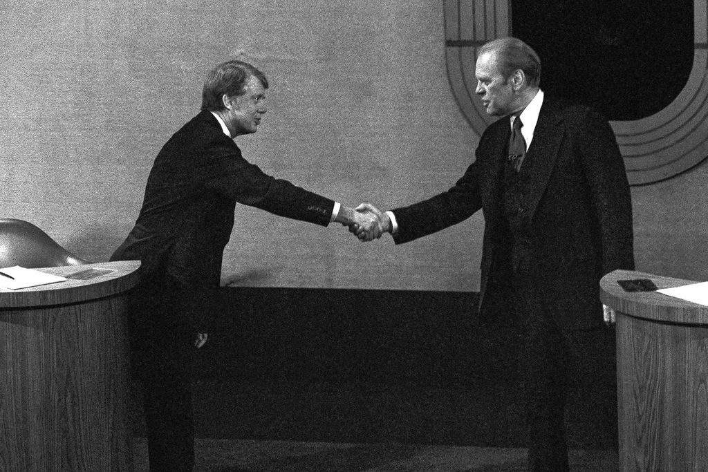 Jimmy Carter (kiri) dan Gerald Ford berjabat tangan sebelum debat presiden ketiga, 22 Oktober 1976, di Williamsburg, AS. 