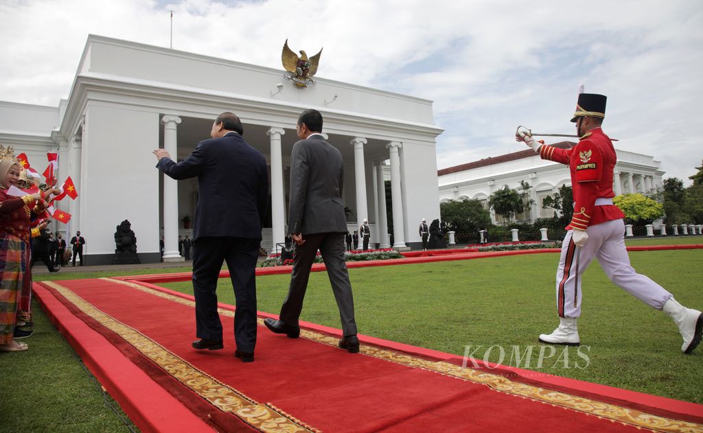 Presiden Joko Widodo bersama Presiden Vietnam Nguyen Xuan Phuc berjalan bersama dalam upacara penyambutan di Istana Kepresidenan, Bogor, Jawa Barat, Kamis (22/12/2022).  