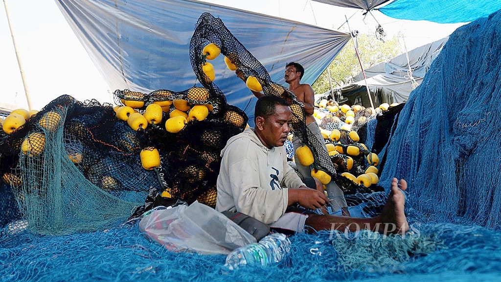 Pekerja memperbaiki jaring untuk menangkap tongkol di kawasan Pelabuhan Perikanan Samudera Nizam Zachman, Muara Baru, Jakarta, Senin (10/4). Para pekerja itu diupah Rp 90.000 per hari.