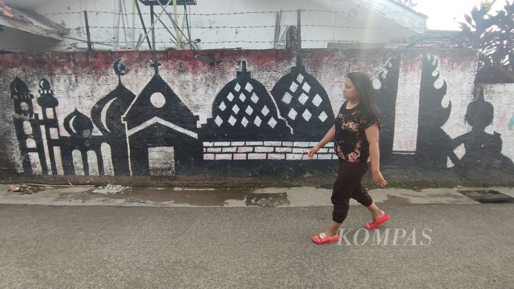 Mural bertema toleransi beragama digambar di sebuah gang di kawasan Pondok Labu, Jakarta, Rabu (6/7/2022). Toleransi alih ejaan dari<i> tolerance</i>, kata dalam bahas Inggris yang tidak ada ataupun sangat jarang/tidak lazim didengar.