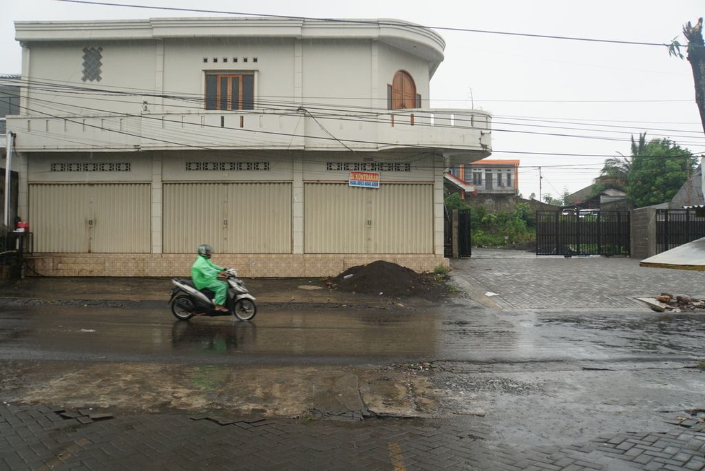 Pengendara sepeda motor melintas menembus hujan di bilangan Malalayang Satu Barat, Manado, Sulawesi Utara, Minggu (17/1/2021). Hujan lebat selama tiga hari yang memicu longsor di beberapa wilayah mennyebabkan enam orang tewas.