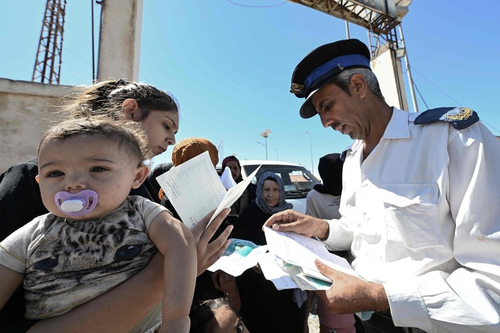 Petugas imigrasi memeriksa berkas para pengungsi dari Lebanon yang hendak melintas ke Suriah di perbatasan Jusiyeh-Quseir, Rabu (2/10/2024).   