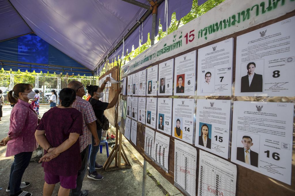 Para pemilih memeriksa informasi tentang kandidat di tempat pemungutan suara di Bangkok, Thailand, Minggu (14/5/2023).  