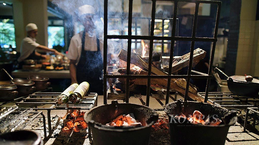 Proses memasak menggunakan kayu bakar di Restoran Agneya di Jalan Wijaya IX, Kebayoran Baru, Jakarta, Rabu (13/12). Restoran ini menyajikan menu masakan Indonesia.