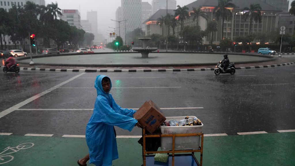 Hujan mengguyur kawasan Bundaran Bank Indonesia, Jakarta Pusat, Jumat (16/10/2020). Hujan deras yang mengguyur Jakarta sejak sore mengakibatkan genangan di sejumlah titik.
