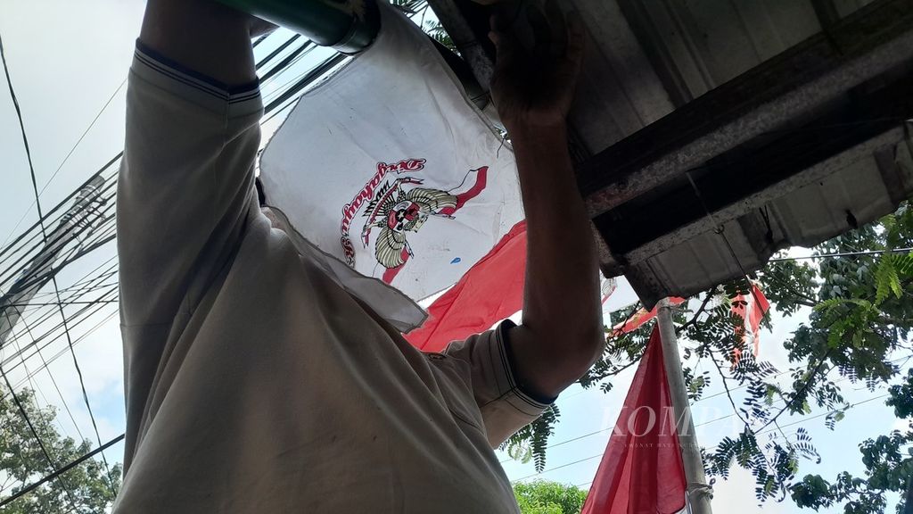 A resident of RT 02 RW 03, Lesanpuro Village, Kedungkandang District, Malang City, East Java, attached a wire to the terrace of a resident's house to install flags along the road on Sunday (30/7/2023). Compared to during the pandemic, the enthusiasm of residents in welcoming the 78th Indonesian Independence Day is more felt.