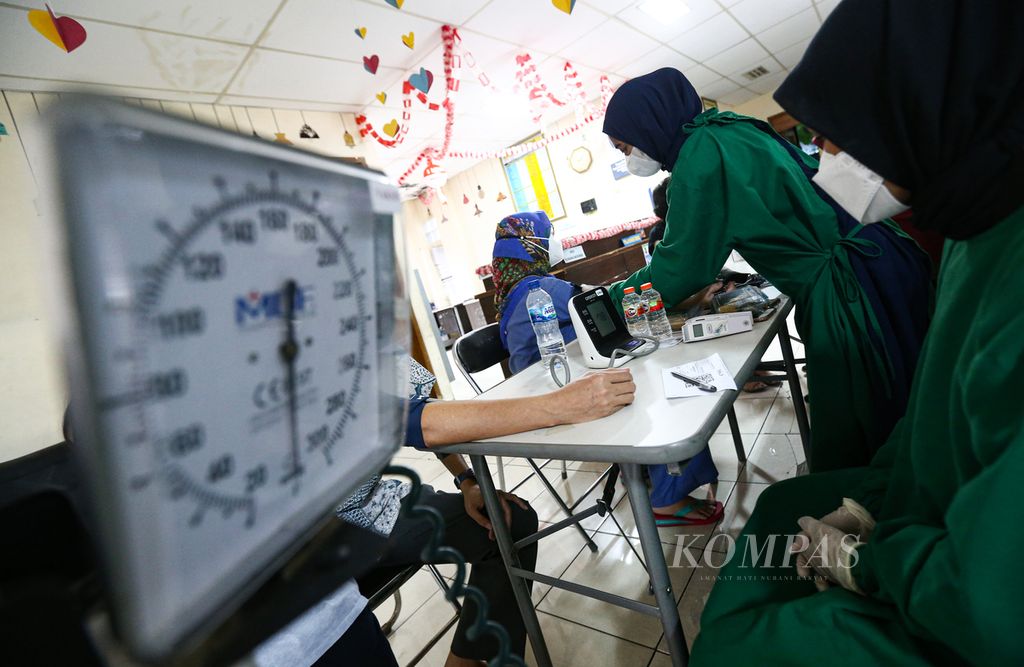 Petugas medis melakukan pemeriksaan tensi darah bagi warga lanjut usia yang akan menerima suntikan vaksin Covid-19 penguat di sentra vaksin di Kelurahan Larangan Selatan, Larangan, Kota Tangerang, Banten, Selasa (8/2/2022).