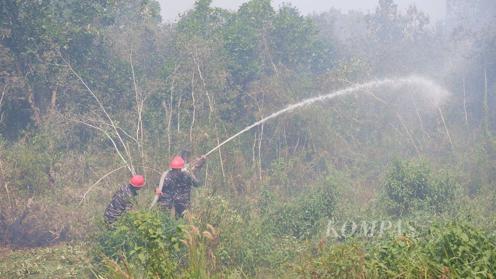 Petugas dari TNI Angkatan Laut berjuang memadamkan kebakaran lahan gambut di Kelurahan Syamsudin Noor, Kecamatan Landasan Ulin, Kota Banjarbaru, Kalimantan Selatan, Sabtu (7/10/2023). 