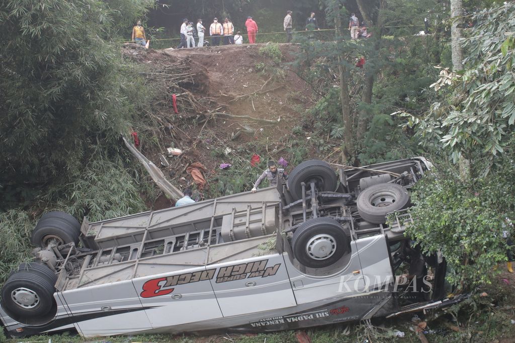 Sejumlah petugas mengamati bus yang mengalami kecelakaan maut di Tanjakan Cae, Desa Sukajadi, Kecamatan Wado, Sumedang, Jawa Barat, Kamis (11/3/2021).