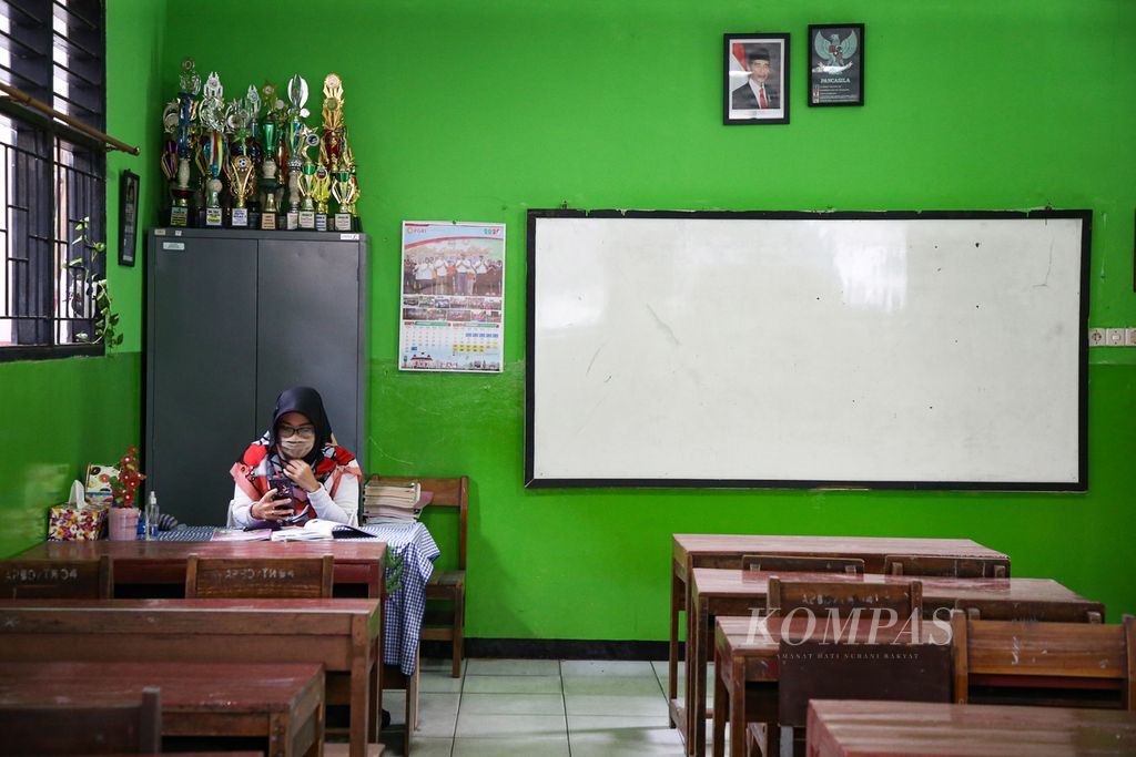 Yayuk, guru di SD Negeri Larangan 1, Kota Tangerang, Banten, mengajar daring di dalam ruang kelas yang kosong, Rabu (24/1/2021). Pembelajaran jarak jauh berlangsung karena pandemi Covid-19 membuat guru dan siswa terbiasa dengan berbagai aplikasi komunikasi dan sistem pembelajaran daring.  