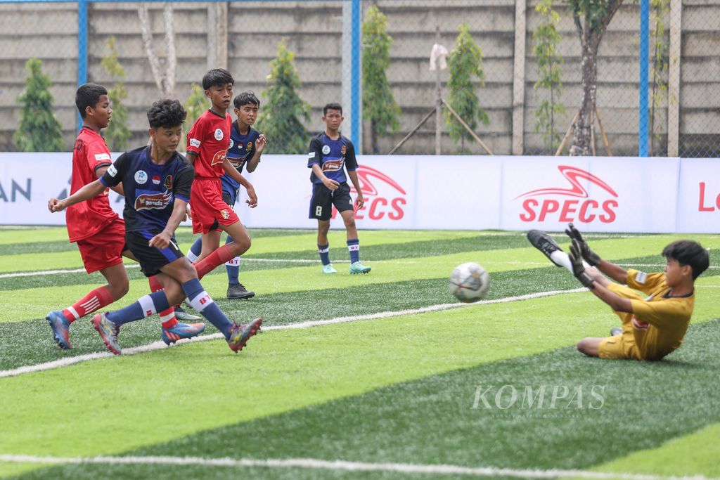 Pemain Bina Taruna, Ferdiyan Mukti (hitam), menendang bola ke arah gawang M-Private dalam babak utama Liga Kompas Kacang Garuda U-14 di Dewantara Sport Center, Tangerang Selatan, Banten, Minggu (26/11/2023). 