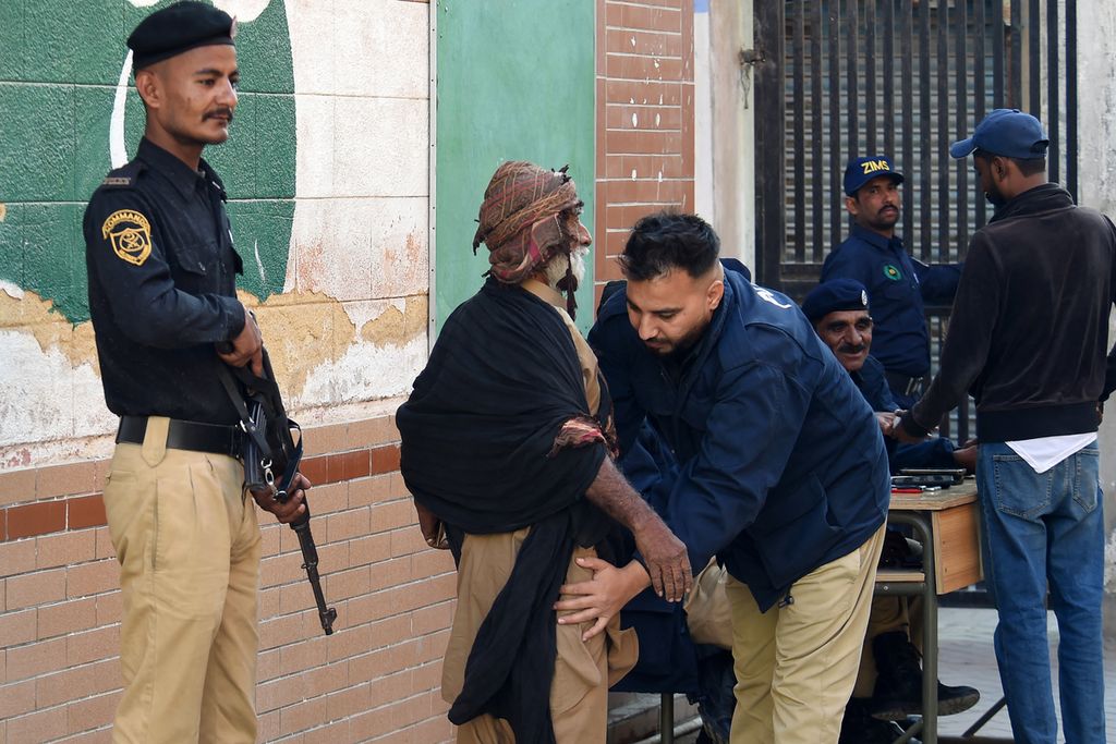 Polisi menggeledah seorang pria yang akan memasuki tempat pemungutan suara untuk memilih pada pemilu nasional Pakistan di Karachi, Kamis (8/2/2024).