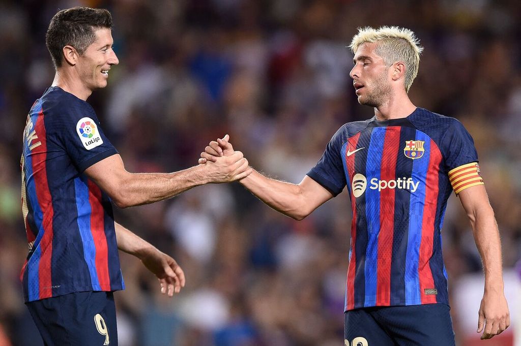 Pemain Barcelona, Sergi Roberto (kanan), dan rekannya, Robert Lewandowski, merayakan gol ke gawang Real Valladolid pada laga Liga Spanyol di Stadion Camp Nou, Barcelona, Spanyol, Senin (29/8/2022) dini hari WIB. Barca menang 4-0 pada laga itu. 