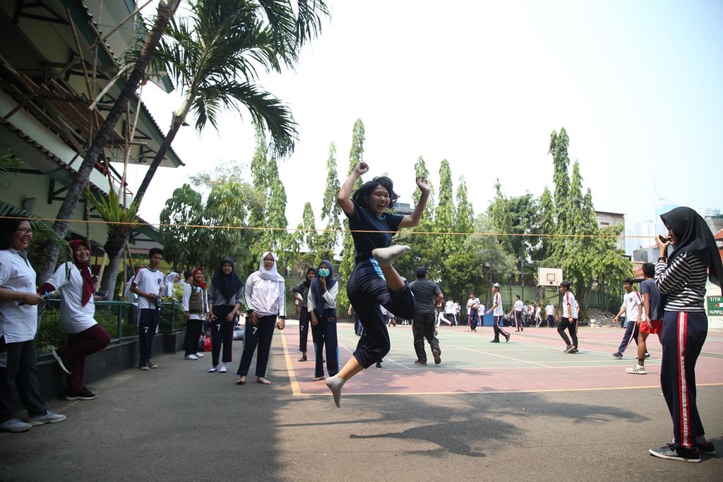 Murid-murid bermain permainan tradisional tali karet saat sehari belajar di luar kelas di SMA Negeri 7 Jakarta, Kamis (7/11/2019). Pelaksanaan sehari belajar di luar kelas dilakukan untuk memenuhi, menjamin, dan melindungi hak anak.