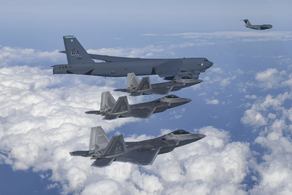 Pesawat pembom B-52 milik Angkatan Udara Amerika Serikat bersama sejumlah jet tempur F-22 dan pesawat logistik pengangkut C-17 melintas di atas Semenanjung Korea pada latihan militer udara bersama, 20 Desember 2022. Sebagian pesawat yang bisa mengangkut bom nuklir itu akan ditempatkan AS di Australia.