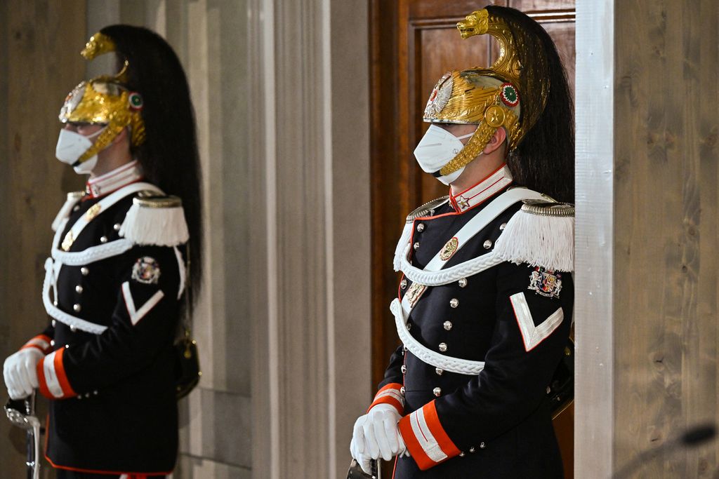 Anggota pengawal presiden Italia, Corazzieri, mengenakan masker saat presiden Italia memulai konsultasi formal untuk membentuk pemerintahan baru di Istana Kepresidenan Quirinal di Roma, 20 Oktober 2022. 