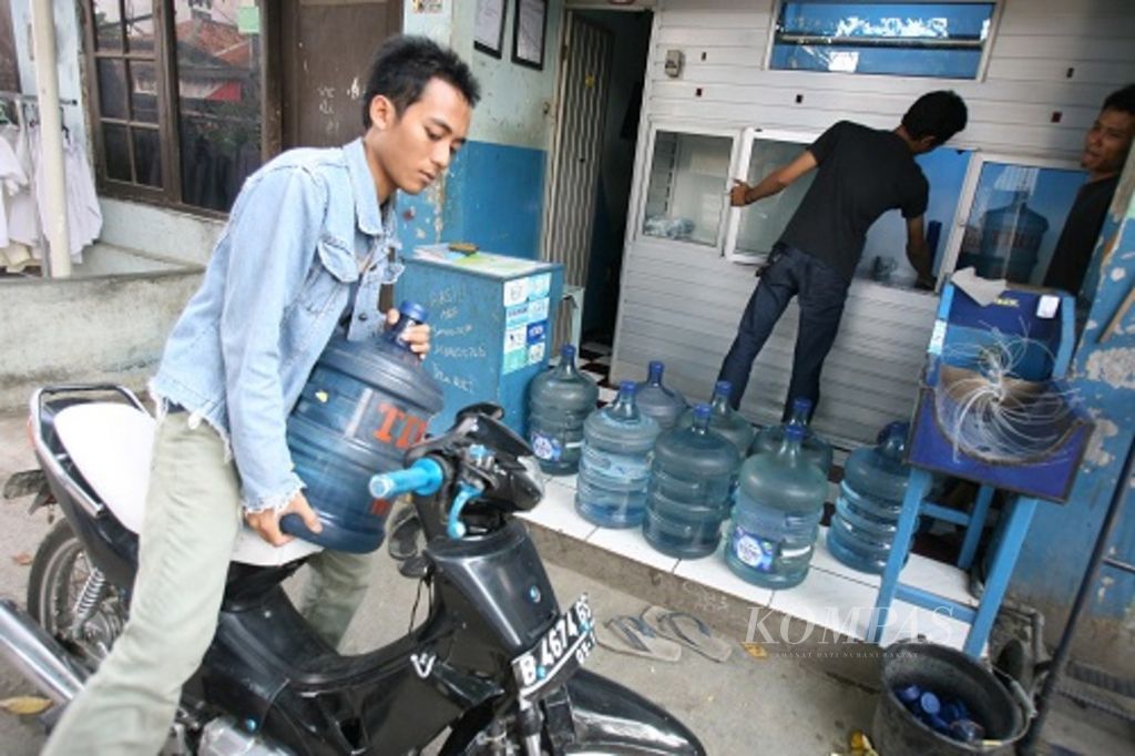 Seseorang tengah membeli air mineral kemasan isi ulang.