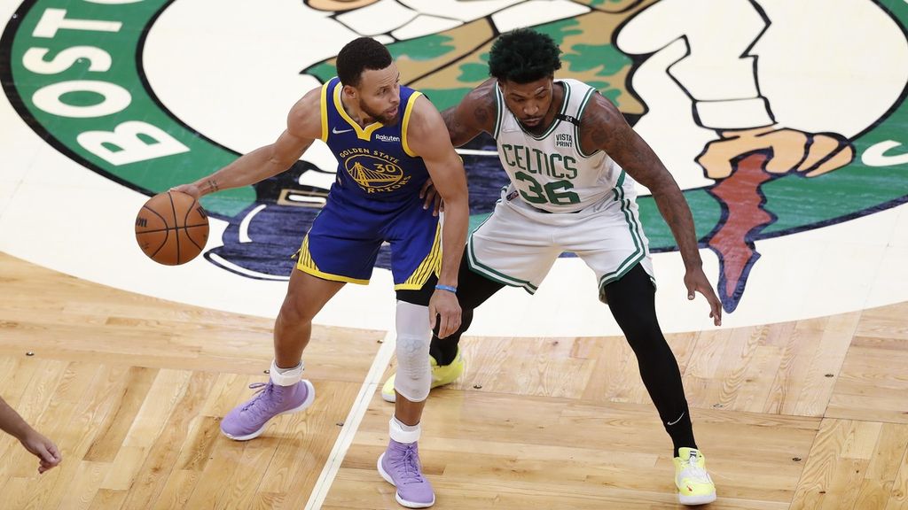 <i>Guard </i>Golden State Warriors, Stephen Curry (kiri), menggiring bola di tengah tekanan <i>guard</i> Boston Celtics, Marcus Smart pada gim keenam final NBA, Juni 2022 lalu di Boston, Amerika Serikat. 