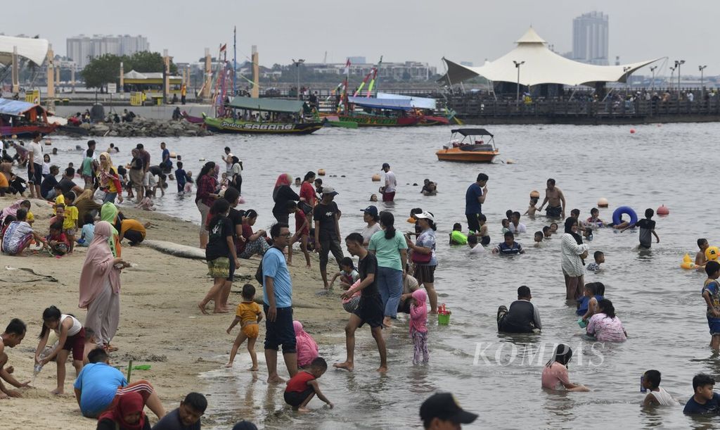 Pengunjung memenuhi area Pantai Lagoon di kawasan wisata Taman Impian Jaya Ancol, Jakarta Utara, Selasa (3/5/2022), 