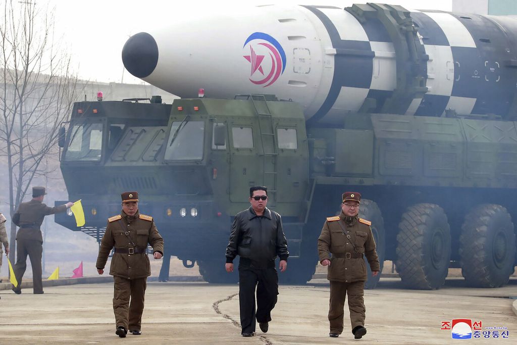 Pemimpin Korea Utara Kim Jong Un (tengah) berjalan di depan rudal balistik antarbenua (ICBM) Hwasong-17 di lokasi yang dirahasiakan di Korea Utara, Kamis (24/3/2022). 