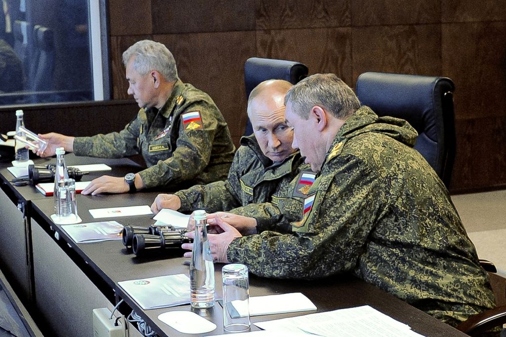 Presiden Rusia Vladimir Putin (tengah) berbincang dengan Kepala Staf Angkatan Bersenjata Rusia Jenderal Valery V Gerasimov (kanan) saat menyaksikan latihan perang Vostok 2022 di Vladivostok, Rusia, 6 September 2022. 