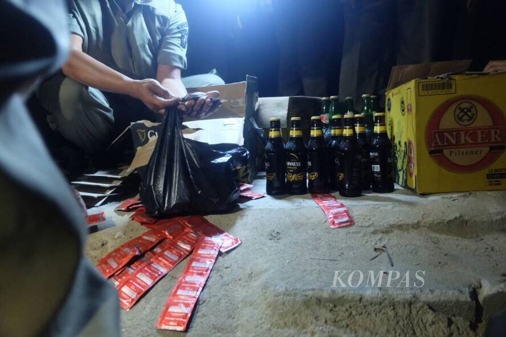 Berbagai barang bukti, seperti kondom dan minuman keras, disita aparat dalam razia di lokasi prostitusi liar di kolong Jalan Tol Sedyatmo, Penjaringan, Jakarta Utara, Jumat (9/6/2017) malam.