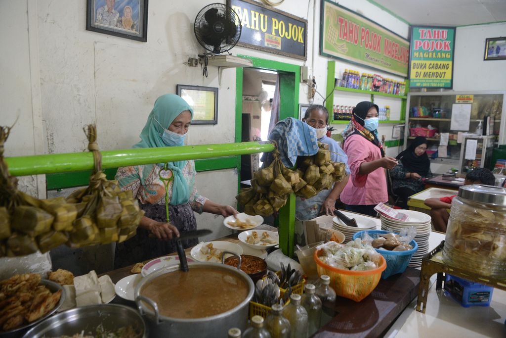 Pelayan menghidangkan tahu kupat pesanan pembeli di rumah makan Tahu Pojok, Kota Magelang, Jawa Tengah, Kamis (11/2/2021). 