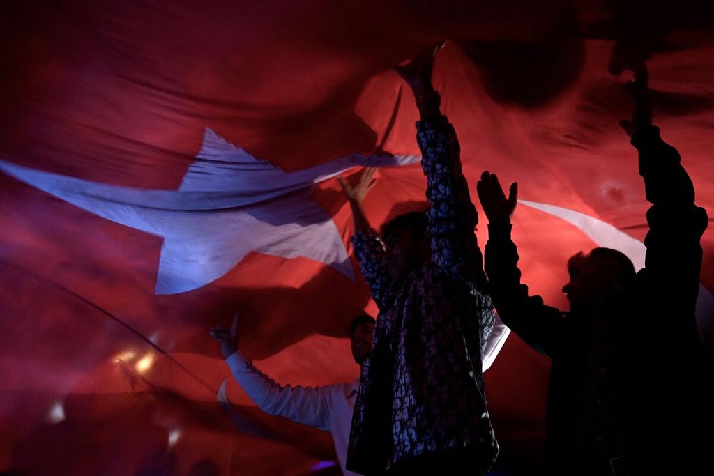 Pendukung Presiden Turki Recep Tayyip Erdogan mengibarkan bendera Turki saat perayaan kemenangan Erdogan dalam putaran kedua pilpres Turki pada Minggu (28/5/2023).