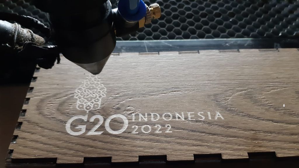 Proses pembuatan gambar tiga dimensi (3D) menggunakan mesin laser pada tempat penyimpanan dasi berbahan kayu di bengkel kerja Hucravindo, salah satu Industri kecil menengah kerajinan kayu di Sidoarjo, Jawa Timur, Senin (7/11/2022). Industri ini terpilih sebagai salah satu souvenir resmi KTT G20 di Bali tahun ini. Produknya antaralain tempat buku, kotak pensil, tempat penyimpanan kartu nama, penyimpanan dasi, dan jam dinding. 