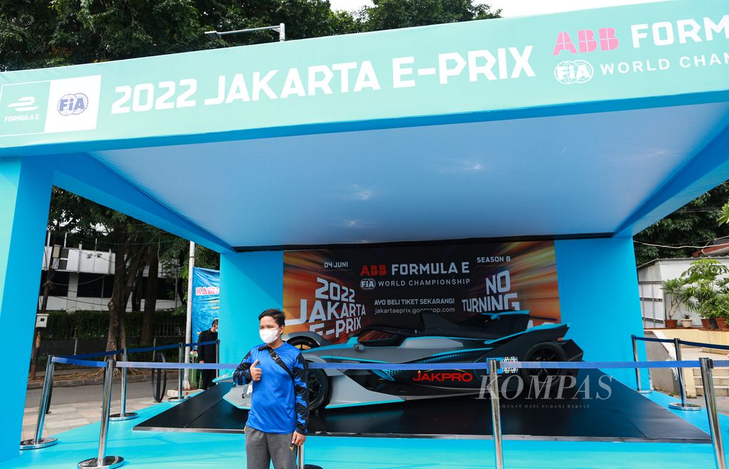 Seorang anak berpose di dekat replika mobil balap Formula E yang dipajang di Bundaran Hotel Indonesia, Jakarta Pusat, Minggu (29/5/2022). Replika mobil balap tersebut menjadi obyek foto warga yang berolahraga di hari bebas kendaraan bermotor.