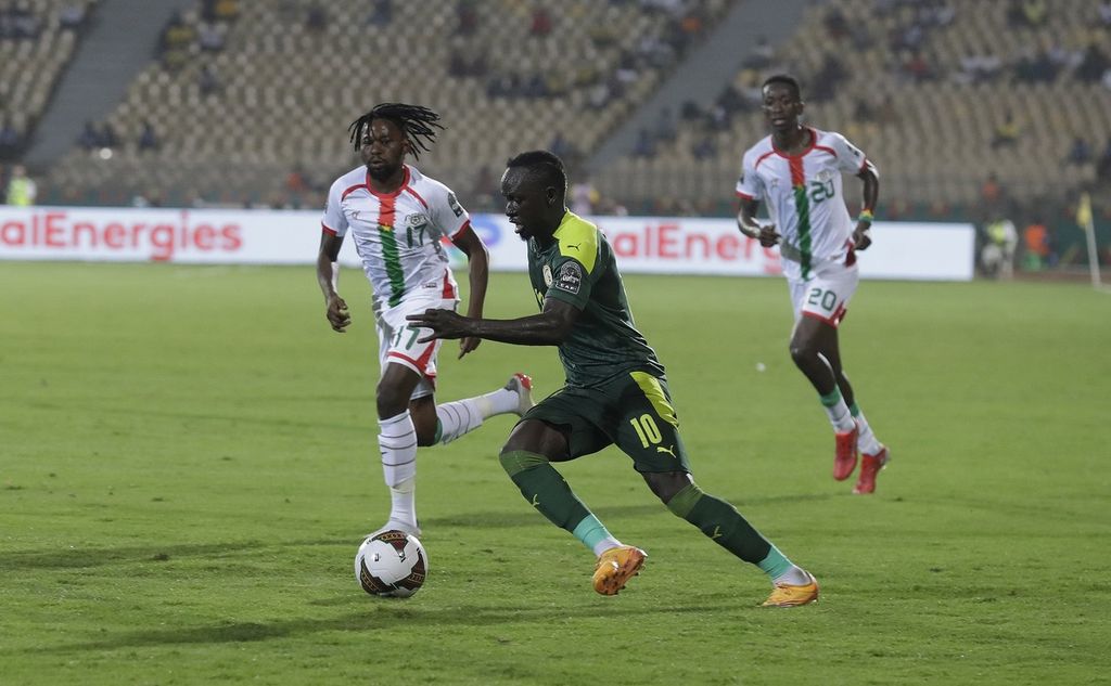 Pemain timnas Senegal, Sadio Mane (tengah), berebut bola dengan pemain Burkina Faso, Zakaria Sanogo, dalam semifinal Piala Afrika di Stadion Ahmadou Ahidjo, Yaounde, Kamerun, Rabu (2/2/2022). Senegal memenangi laga itu dengan skor 3-1. 