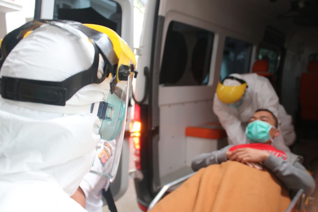 Dua petugas dengan alat pelindung diri (APD) membawa karyawan yang berperan sebagai pasien ke dalam ambulans khusus dalam simulasi penanganan pasien terduga Covid-19 di Rumah Sakit Hasan Sadikin, Bandung, Jumat (6/3/2020). Simulasi ini melibatkan lebih kurang 50 petugas.
